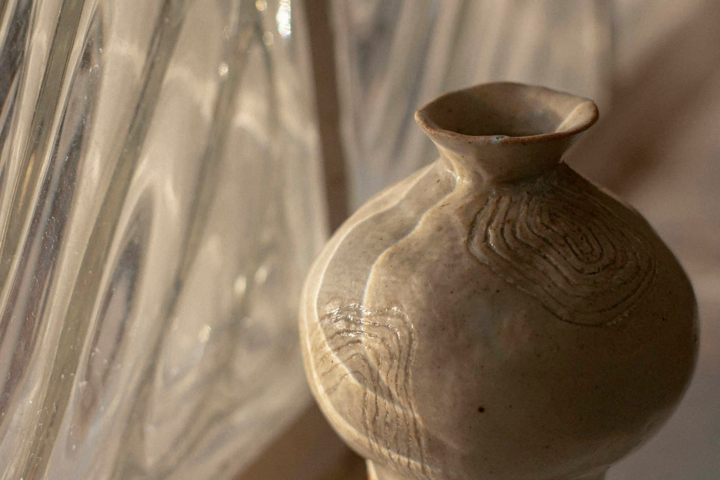 عروق بلوط خام بجانب كتان مطوي وكوب من الطين